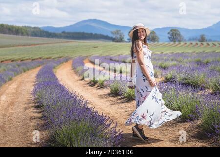Portrait von schönen romantischen Frau Blumenkleid und stilvollen Hut dain Feld von Lavendelblüten Stockfoto