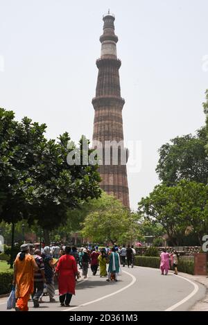 DELHI, INDIEN Touristen besuchen Qutub Minar, höchste Minarett. Turm aus Marmor und rotem Sandstein ist eine Touristenattraktion. Ruinen von Mughal Stockfoto