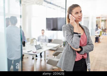 Junge Geschäftsfrau telefoniert mit dem Smartphone Stockfoto