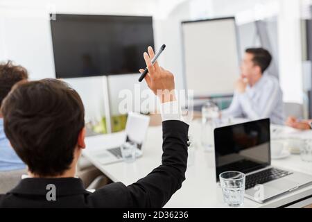 Geschäftsfrau hebt Hand in Team-Meeting bei Videokonferenz Stockfoto