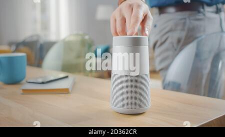 Man schaltet Smart Speaker ein, der Künstliche Intelligenz-Assistent aktiviert. Stockfoto