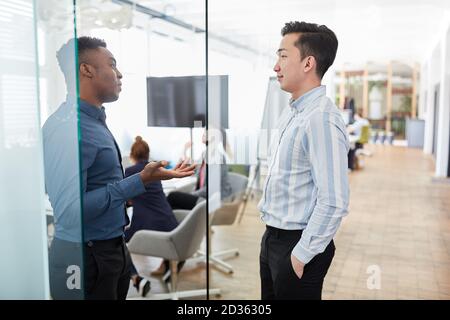Zwei junge Geschäftsleute diskutieren in der über ein Business-Projekt Büroflur Stockfoto