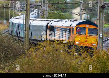 Diesel-Elektrolokomotive der Baureihe 66, die einen Drax-Biomassezug an der Kreuzung Winwick auf der West Coast Main Line schleppt. Stockfoto