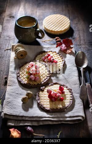 Waffeln in Schokolade mit Obst und Kaffee.gesunde Lebensmittel und Getränke.leckeres Frühstück.Holztisch. Stockfoto