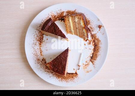 Die Reste des Kuchens und der Kerze. Halbgessene Torte nach der Party. Das Ende des Urlaubs. Was nach dem Geburtstag übrig bleibt. Verlassene Schokolade c Stockfoto