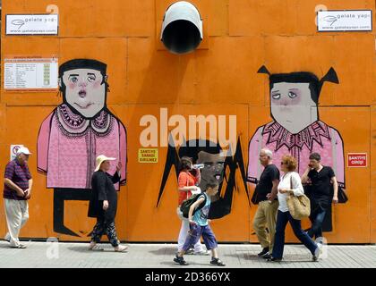 Fußgänger kommen an einem bunten Wandgemälde vorbei, das auf temporäre Schalungen eines Gebäudes auf Istiklal Caddesi im türkischen Taksim-Viertel von Istanbul gemalt wurde. Stockfoto