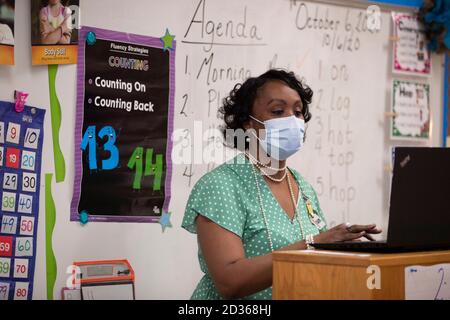 Austin, TX USA 6. Oktober 2020: Unter der aufmerksamen Aufsicht von erfahrener Erstklässellehrerin Nicole Miller und mit viel PPE-Vorbereitung, hebt das persönliche Lernen am zweiten Unterrichtstag im Campbell Elementary in Austin wieder an. Der öffentliche Campus des Austin Independent School District nutzt im Zeitalter des Coronavirus eine Kombination aus fernem und personellem Lernen. Kredit: Bob Daemmrich/Alamy Live Nachrichten Stockfoto