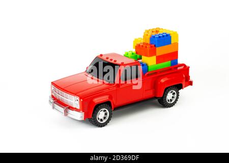 Bunte Würfel im roten trendigen Pickup-Kofferraum. Spielzeug LKW und Puzzles. Modernes Bau- und Entwicklungskonzept. Teil des Sets. Stockfoto