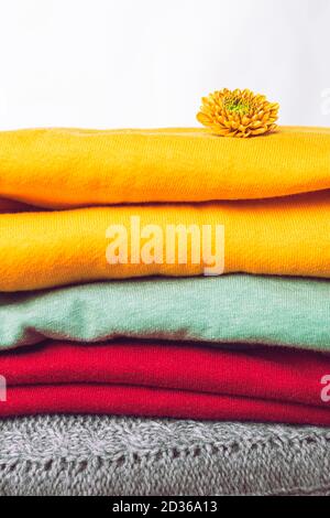 Nahaufnahme von trendigen Farben Kleidung für kaltes Wetter, Herbst und Winter Pullover. Ein Stapel warmer Herbst- oder Winterkleidung. Wäscherei, Online-Shopping, Trend Stockfoto