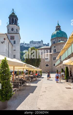 Menschen sitzen an einem sonnigen Sommernachmittag in einem Café vor dem Salzburger Dom (Dom zu Salzburg). Stockfoto