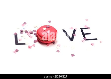 Liebe. Rosa Makronen und handgezeichnete Buchstaben mit kleinen Herzen. Sweet Love Konzept. Stockfoto