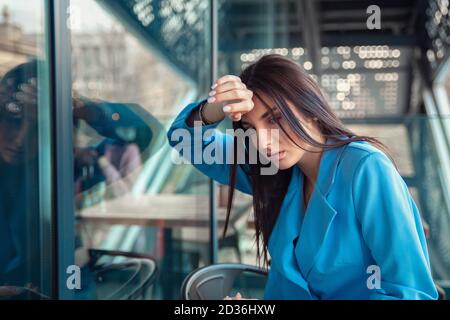 Closeup Portrait unglücklich junge Geschäftsfrau, Kopf im Fenster "" störte versehentlich mit Kopfschmerzen isoliert Hintergrund Unternehmenszentrale. Negative Stockfoto