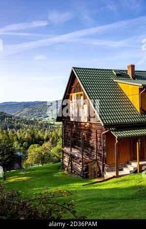 Traditionelles braunes Holzhaus in polnischem Highlander-Bergstil auf einem Hügel in einem Dorf im Zywiec Beskid-Gebirge, Milowka, Polen. Stockfoto