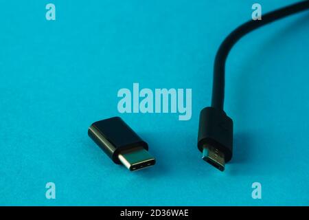 Micro USB auf Typ C kleiner Adapter und Kabel an Blauer Hintergrund Stockfoto