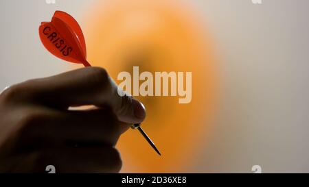 Dart und orangefarbener Ballon symbolisieren die Weltkrise. Stockfoto