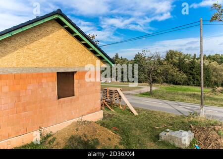 Bau eines Familienhauses im Dorf. Leere Baustelle. Ziegelwand. Neues Haus. Stockfoto