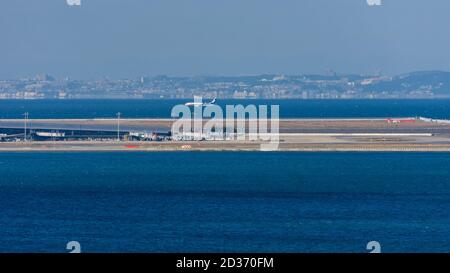 Osaka / Japan - 16. November 2017: ANA-Flugzeug landet auf dem Kansai International Airport, einer künstlichen Insel in der Bucht von Osaka, mit der Stadt Kobe visibl Stockfoto