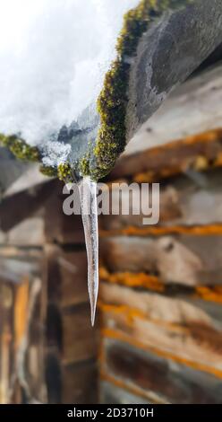 Eiszapfen hängen vom Dach des Hauses Stockfoto