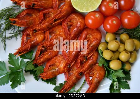 Gekochte Garnelen mit frischen Kräutern, Oliven, Limette und Tomaten Stockfoto