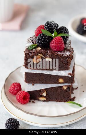 Nahaufnahme von Brownie-Schokoladenstückchen mit Beeren. Stockfoto