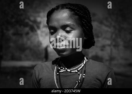 Tsaranoro Camp, Andringitra Nationalpark, Zentral Madagaskar - November 2018: Schöne gebürtige madagassische Frau, die mit einem kleinen Lächeln links von der Seite schaut Stockfoto