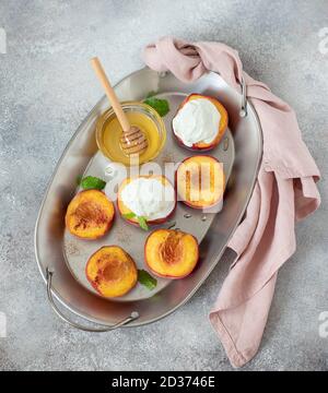 Gegrillte Pfirsiche mit einer Kugel Eis, Honig. Stockfoto