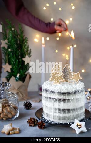 Hausgemachte Weihnachtskuchen und Frau Hände Kerzen anzünden Stockfoto