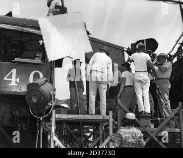 JAMES CAGNEY und RAOUL WALSH am Drehort offen mit Movie Crew im Chatsworth Los Angeles Kalifornien Dreharbeiten Bahnraub Szene für WHITE HEAT 1949 Regisseur RAOUL WALSH Drehbuch Ivan Goff und Ben Roberts vorgeschlagen von einer Geschichte von Virginia Kellogg Musik Max Steiner Warner Bros. Stockfoto