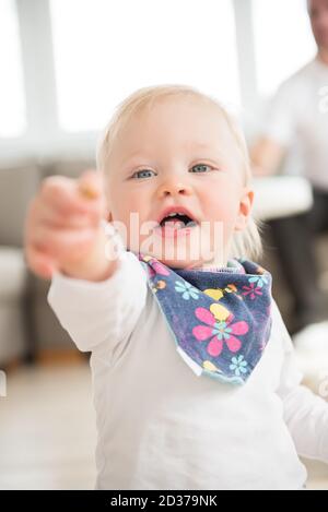 Portrait von schön gekleidet und glücklich Baby-Mädchen zeigt mit Finger. Stockfoto