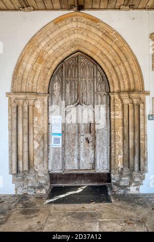 Frühe englische Tür in Südveranda der Allerheiligen Kirche, Thornham in Nord-Norfolk. Stockfoto