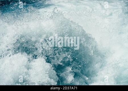 Gefrorenes Planschen in Stromschnellen des mächtigen Gebirgsflusses. Surfen im klaren Wasser aus der Nähe. Natur Hintergrund mit Flut von azurblauem Wasser. Eingefrorene spl-Bewegung Stockfoto