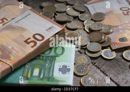 Isoliertes Bild von Euro-Münzen und -Banknoten in vielen europäischen Ländern Länder auf Holzhintergrund Stockfoto