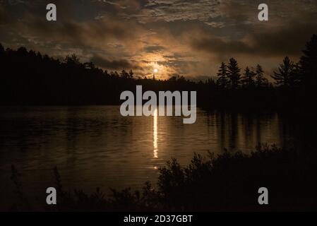 Mond steigen nach einem Sturm vorbei, über einem kleinen See in Nord-Ontario. Stockfoto