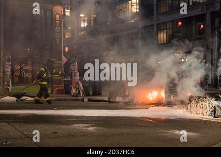 Seattle, USA. September 2020. Am frühen Abend lösch die Feuerwehr Mülltonnen, die von Protestierenden in Brand gesetzt wurden. Stockfoto