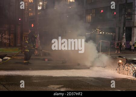 Seattle, USA. September 2020. Am frühen Abend lösch die Feuerwehr Mülltonnen, die von Protestierenden in Brand gesetzt wurden. Stockfoto