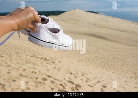 Weiße Wanderschuhe auf dem Hintergrund der Pilat Düne, der größten Sanddüne Europas Stockfoto