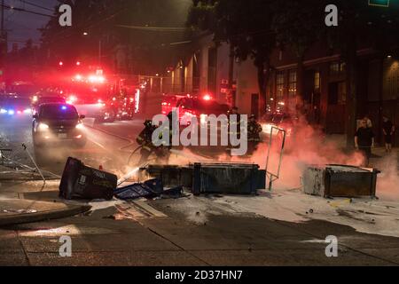 Seattle, USA. September 2020. Am frühen Abend lösch die Feuerwehr Mülltonnen, die von Protestierenden in Brand gesetzt wurden. Stockfoto