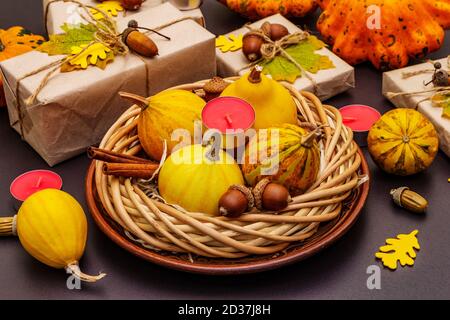 Tischdesign im Herbst. Thanksgiving oder Halloween Konzept. Handgefertigte Geschenkboxen, Herbstdekor und Duftkerzen. Steinbeton Hintergrund, Nahaufnahme Stockfoto
