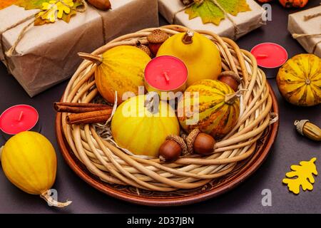Tischdesign im Herbst. Thanksgiving oder Halloween Konzept. Handgefertigte Geschenkboxen, Herbstdekor und Duftkerzen. Steinbeton Hintergrund, Nahaufnahme Stockfoto