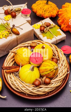 Tischdesign im Herbst. Thanksgiving oder Halloween Konzept. Handgefertigte Geschenkboxen, Herbstdekor und Duftkerzen. Steinbeton Hintergrund, Nahaufnahme Stockfoto