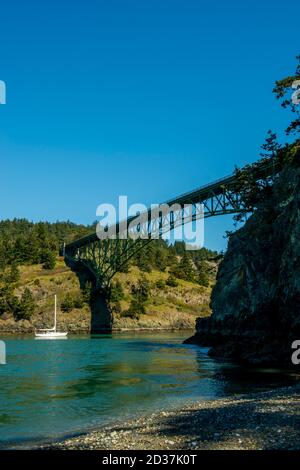 Blick auf Deception Pass Bridge und Segelboot vom North Beach des Deception Pass State Park auf Whidbey Island, Washington State, USA. Stockfoto