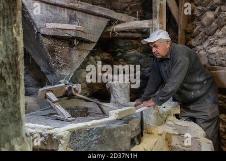 Alte Mühle zum Mahlen von Getreide aus nächster Nähe. Der Müller mahlt Getreide Stockfoto
