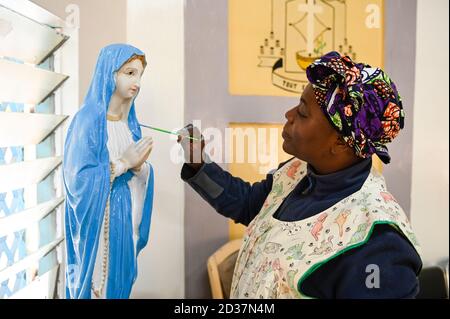 NIGER, Maradi, Kathedrale, Ordensschwester mit einer Statue der Mutter maria / Kathedrale, Ordensschweister bemalt eine Marienfigur Stockfoto