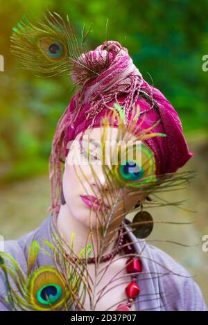 Junge Frau in traditioneller Kleidung und Federn Porträt Stockfoto