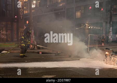 Seattle, USA. September 2020. Am frühen Abend lösch die Feuerwehr Mülltonnen, die von Protestierenden in Brand gesetzt wurden. Stockfoto