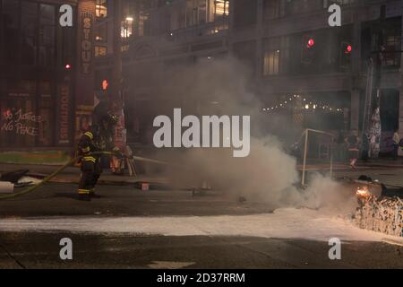 Seattle, USA. September 2020. Am frühen Abend lösch die Feuerwehr Mülltonnen, die von Protestierenden in Brand gesetzt wurden. Stockfoto