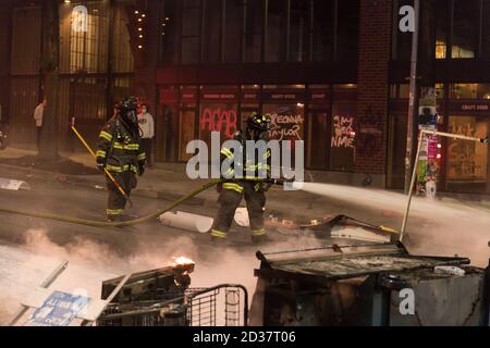 Seattle, USA. September 2020. Am frühen Abend lösch die Feuerwehr Mülltonnen, die von Protestierenden in Brand gesetzt wurden. Stockfoto