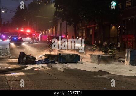 Seattle, USA. September 2020. Am frühen Abend lösch die Feuerwehr Mülltonnen, die von Protestierenden in Brand gesetzt wurden. Stockfoto