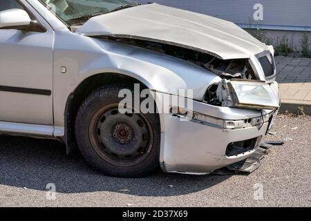 Silber Auto mit seiner Front abgestürzt, Platten gebeult und gebrochen auf Asphalt Straße, Detail zu beschädigten Teil Stockfoto