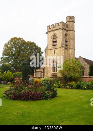 Chenies Manor Gärten im September mit St. Michael's Kirche. Statue des Amors in einem runden Blumenbett. Stockfoto